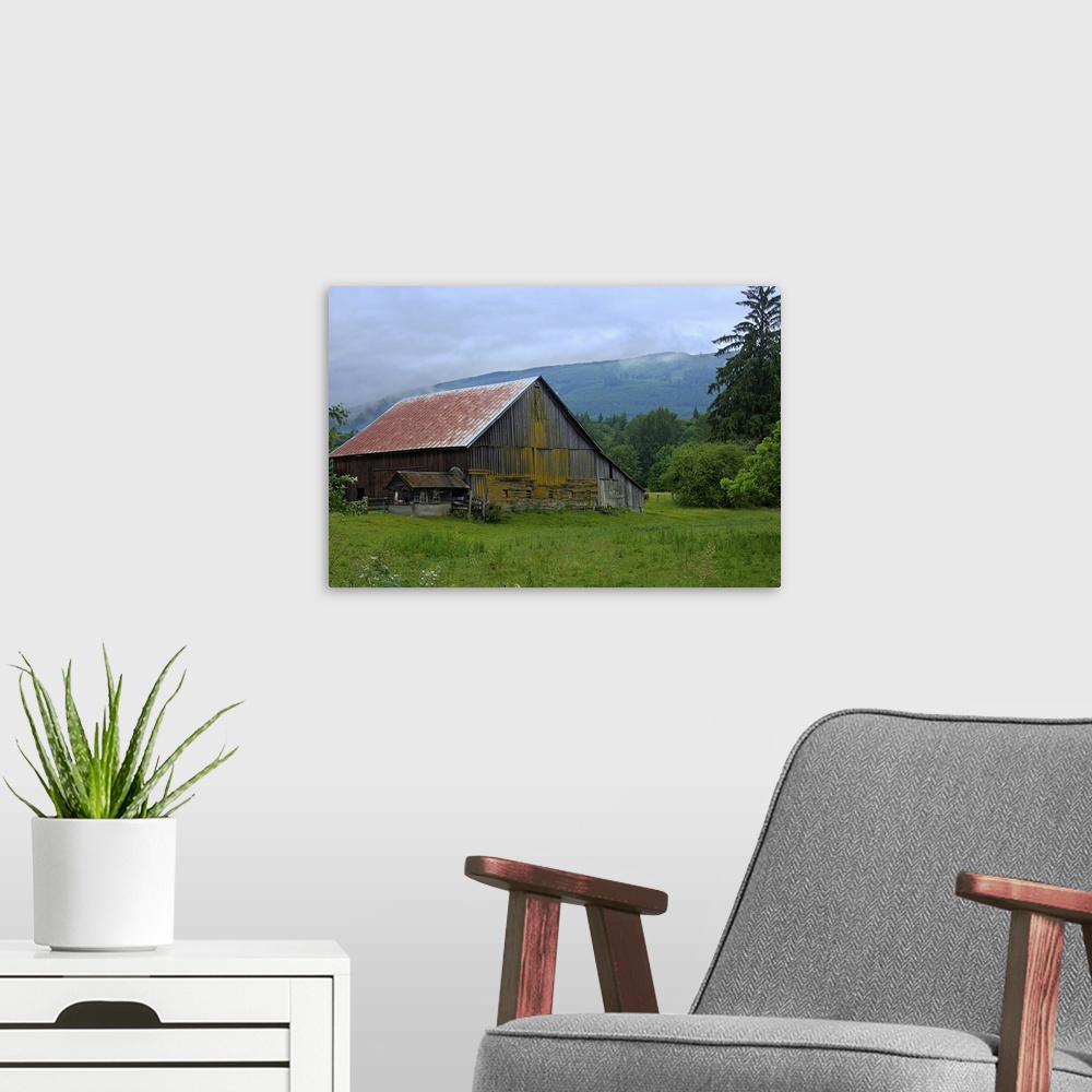 A modern room featuring An old wooden barn in a rural field surrounded by fog.