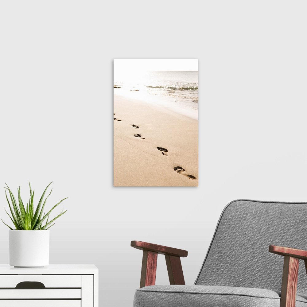 A modern room featuring Photograph of a line of footprints in the sand in front of the ocean.