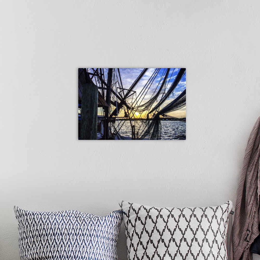 A bohemian room featuring Photograph of the sunrise though boat lines and nets.