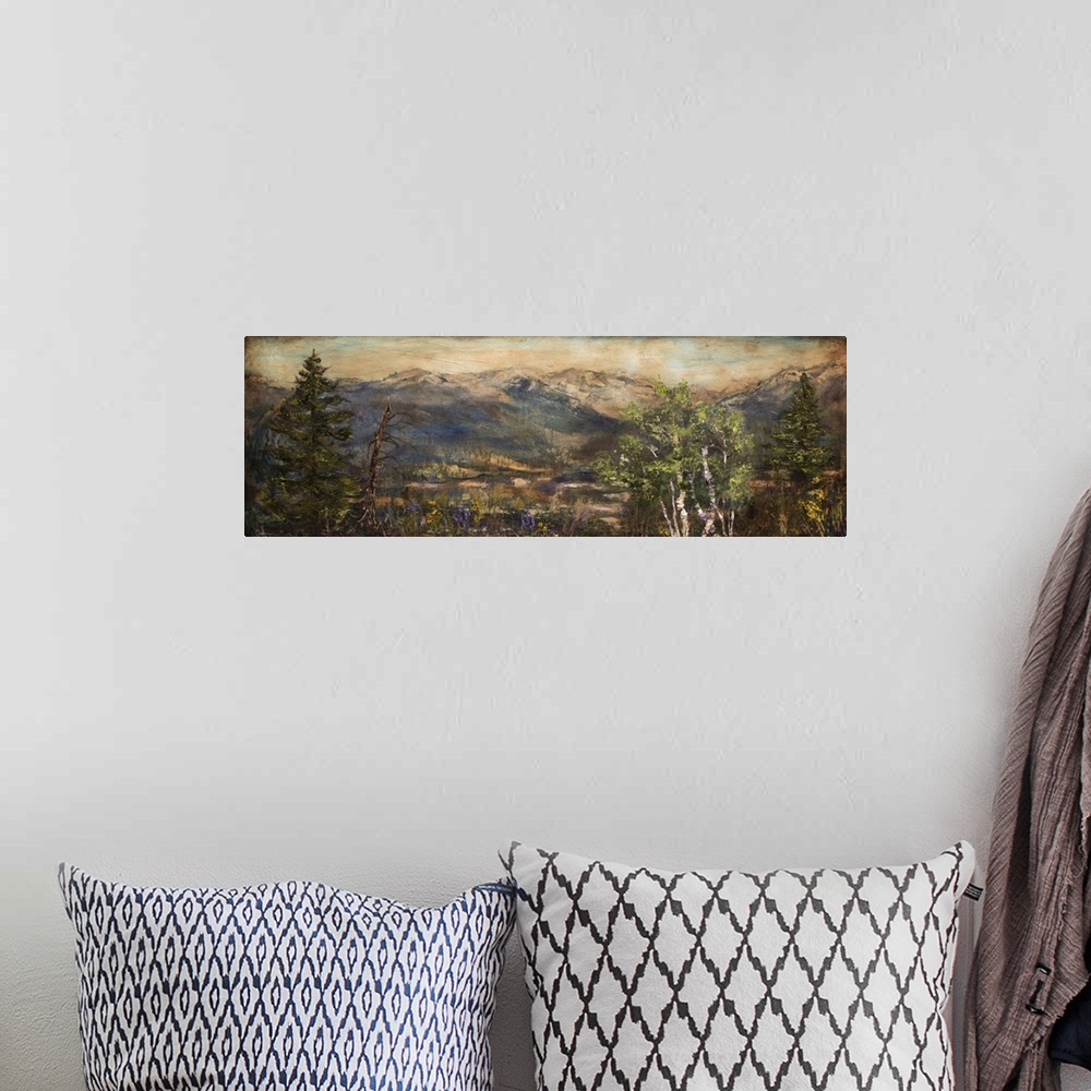 A bohemian room featuring Wide painting of a mountain scene with  purple and yellow wildflowers and green trees in the fore...