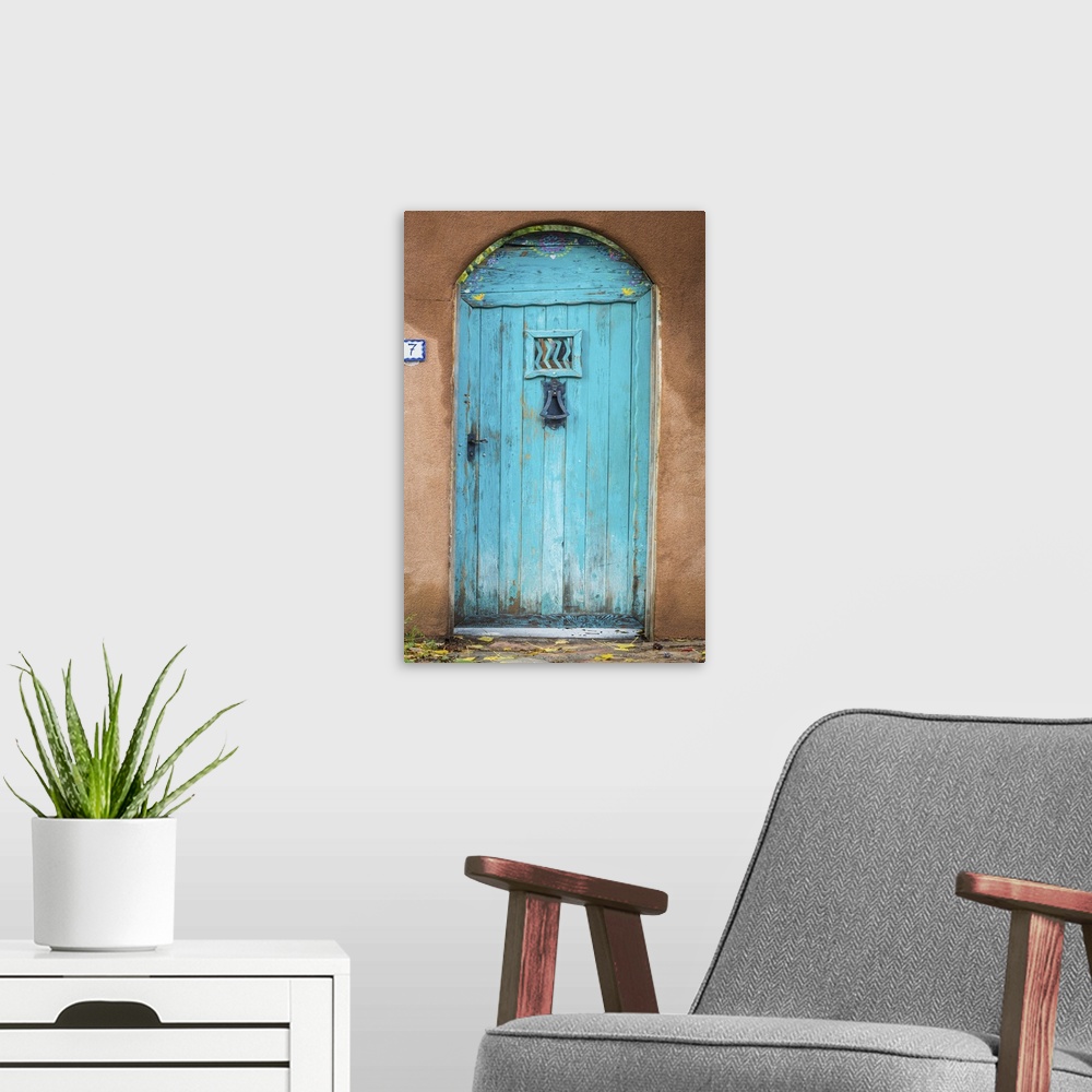 A modern room featuring Photograph of a bright blue door in an adobe wall.