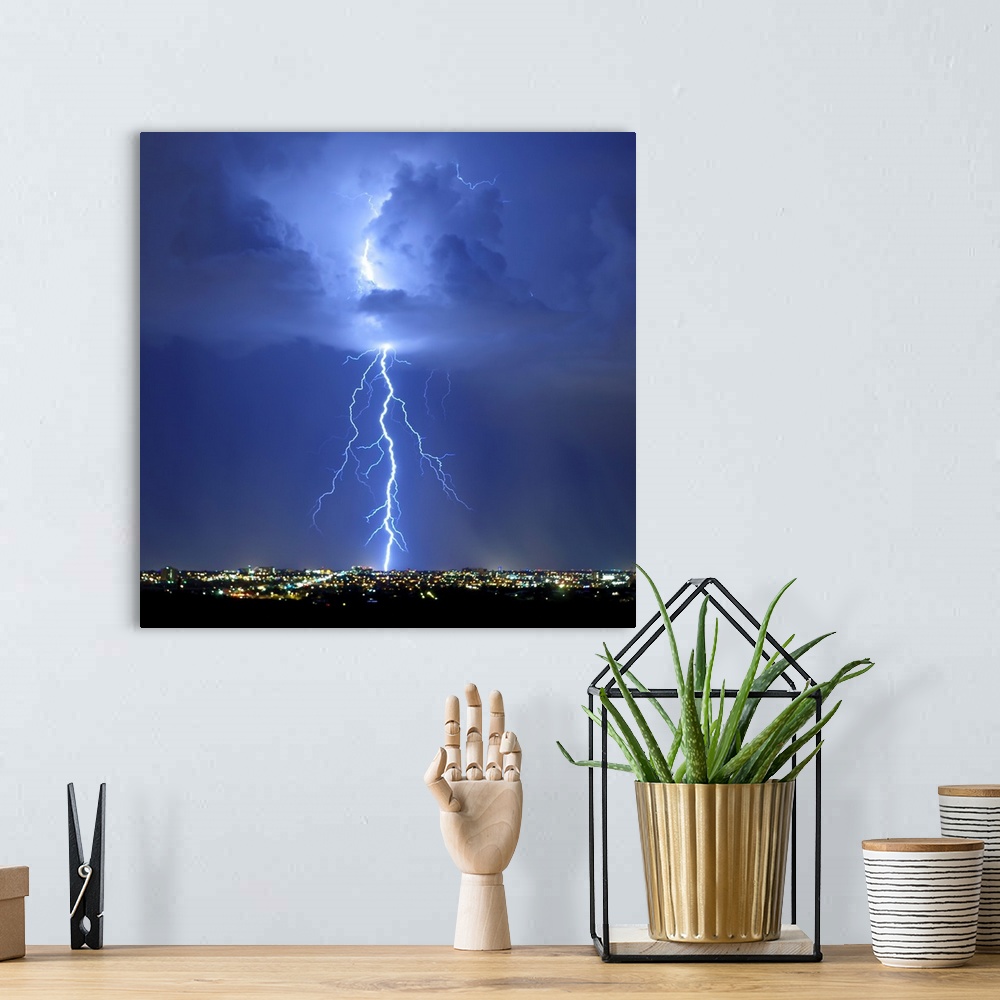 A bohemian room featuring Square photograph of lightning bolts in a blue sky above an Arizona city.