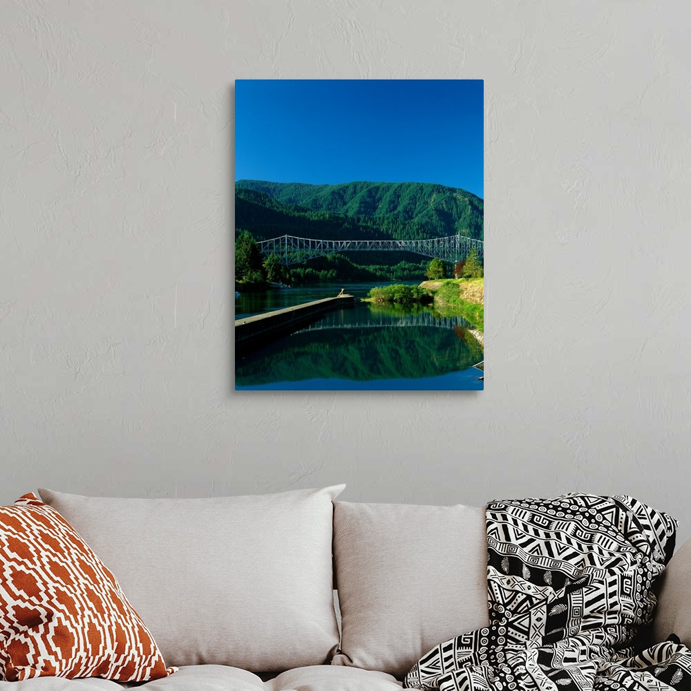 A bohemian room featuring Photograph of the Columbia river with the Bridge of the Gods going over it and lush mountains in ...