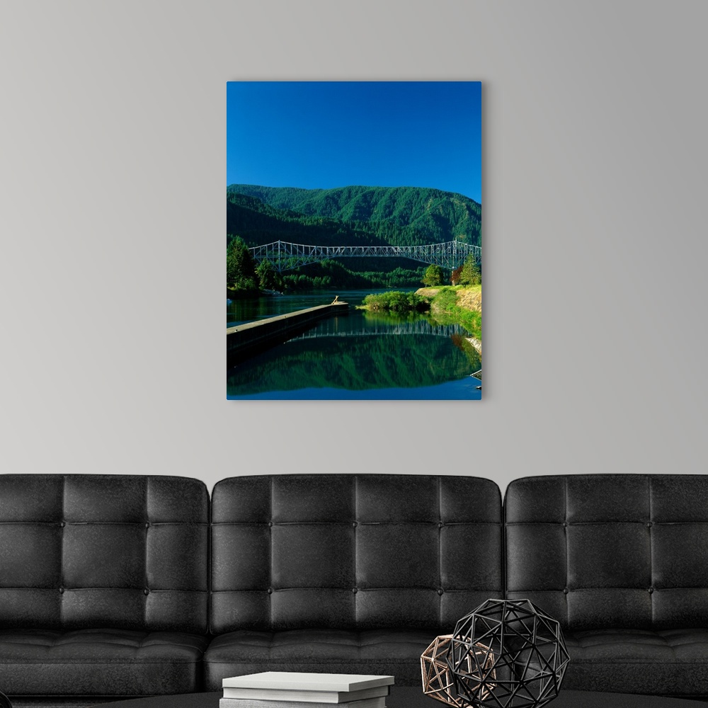 A modern room featuring Photograph of the Columbia river with the Bridge of the Gods going over it and lush mountains in ...