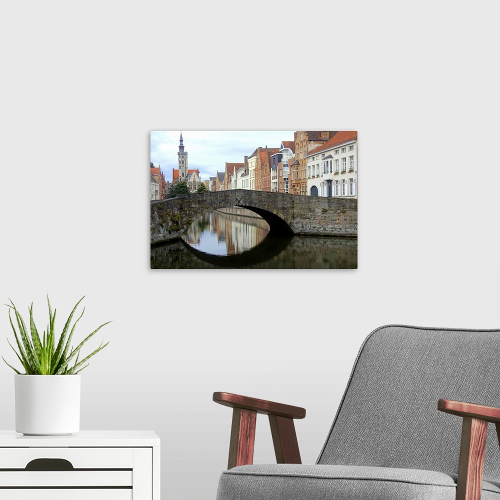 A modern room featuring Photograph of an old stone bridge in Belgium over a river.