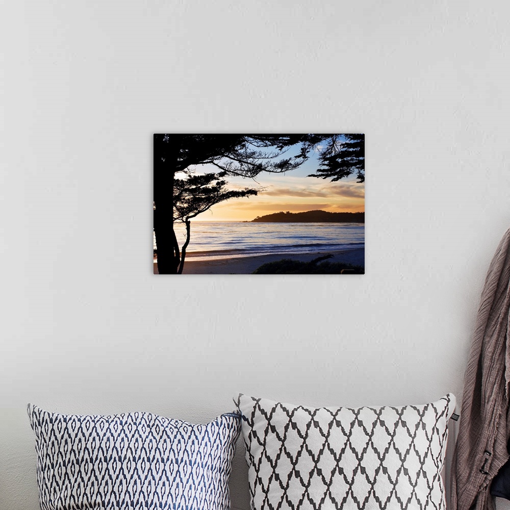 A bohemian room featuring This landscape photograph of waves rocking against the seashore and the silhouette of a beach pin...