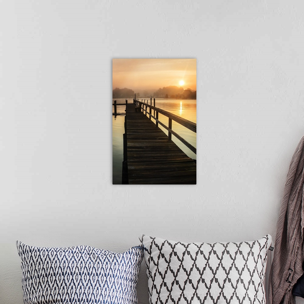 A bohemian room featuring Silhouetted pier on a calm ocean in orange sunrise light.