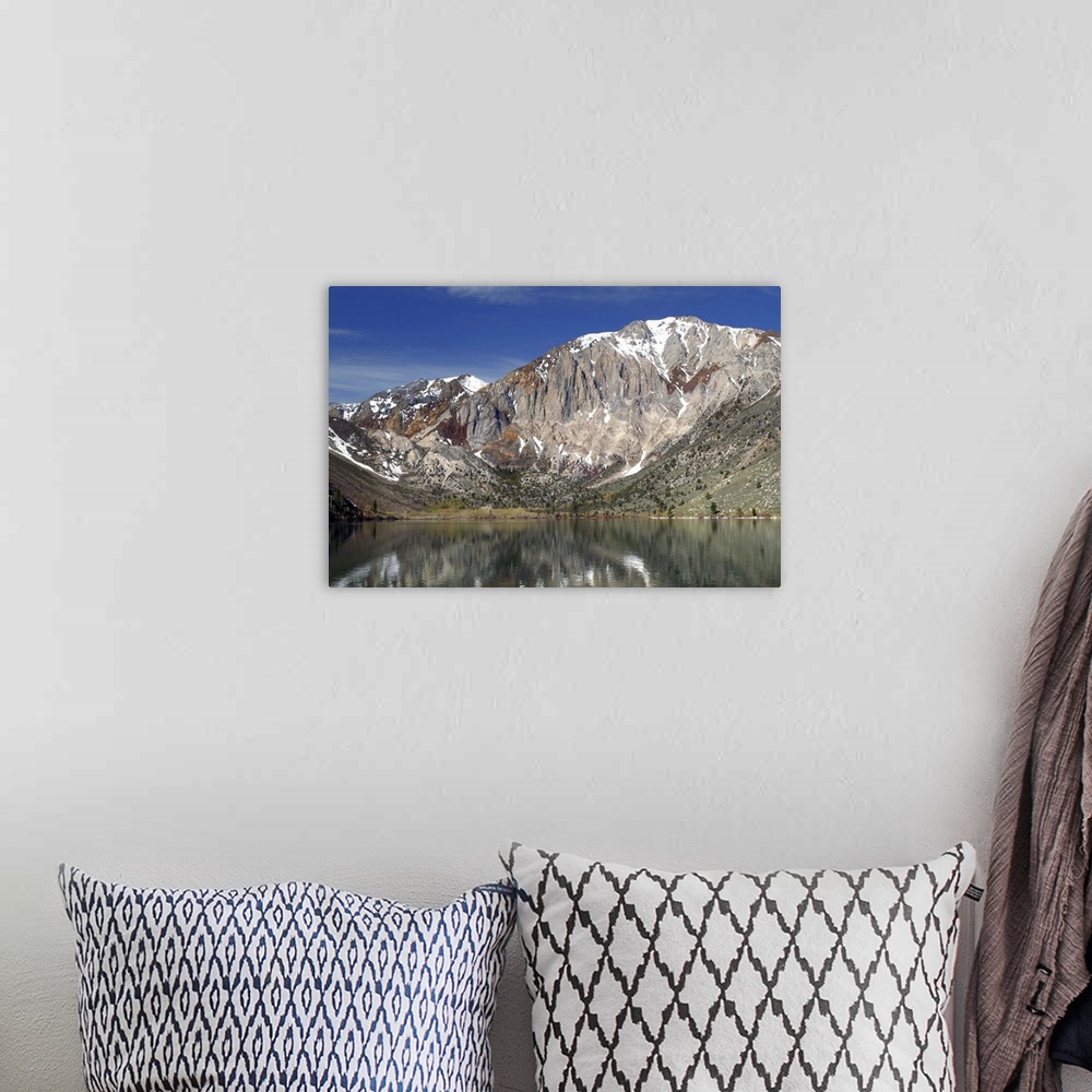 A bohemian room featuring Landscape photograph of Convict Lake with a rocky mountain range in the background.