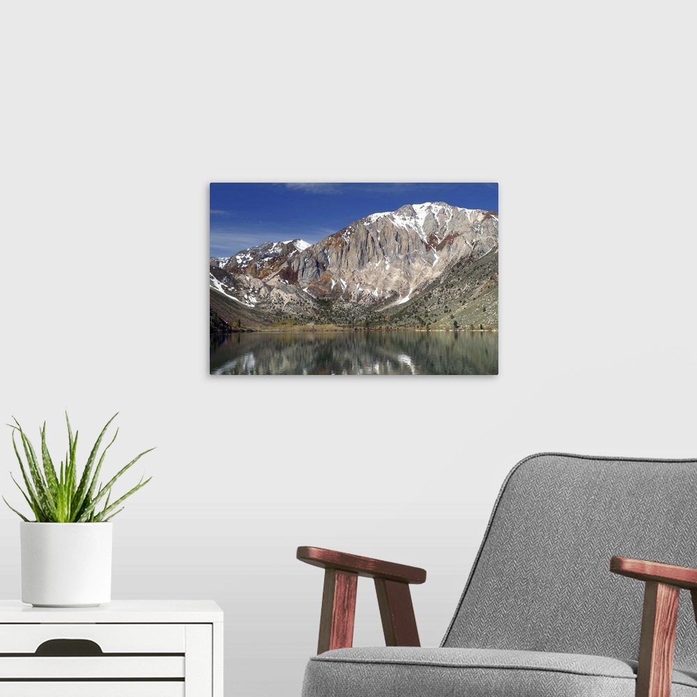 A modern room featuring Landscape photograph of Convict Lake with a rocky mountain range in the background.