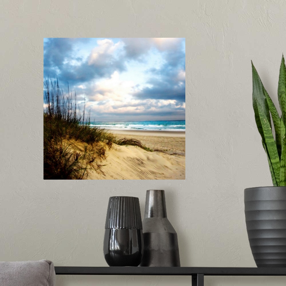 A modern room featuring Soft focus fine art photo of sand dune covered in reeds on the beach as blue water crashes on the...