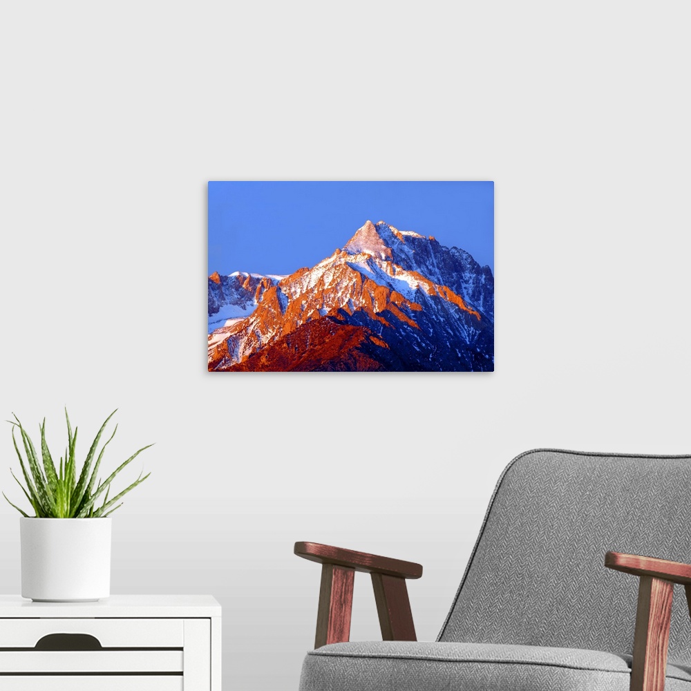 A modern room featuring Photograph of Mount Williamson with golden lit snowy peaks at sunrise.