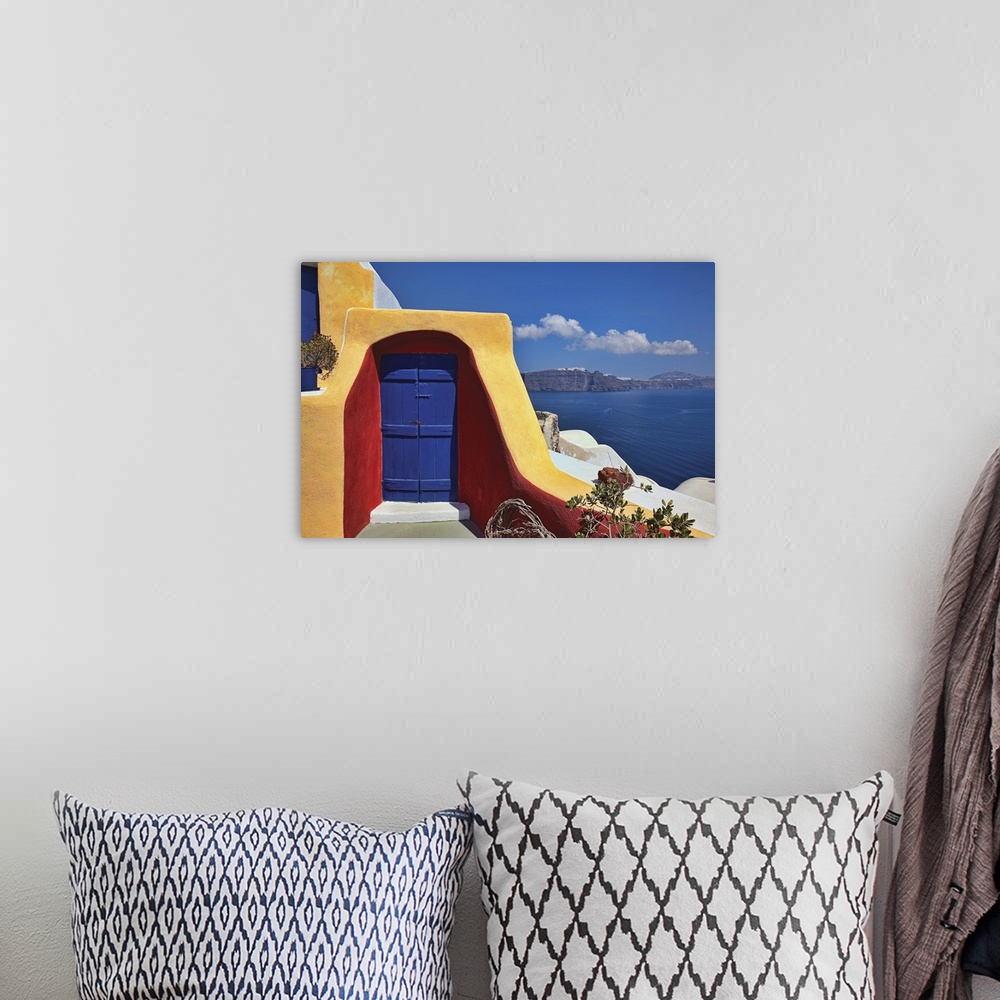 A bohemian room featuring Photo on canvas of a doorway of a house on a cliff overlooking the ocean.