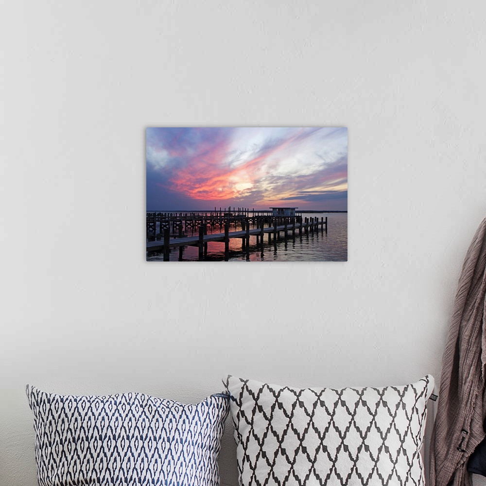 A bohemian room featuring Landscape photograph on a big wall hanging of several docks lined next to each other, in calm wat...
