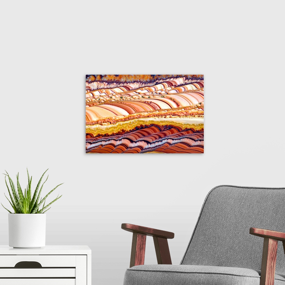 A modern room featuring Abstract photograph resembling colorfully striped rolling hills.