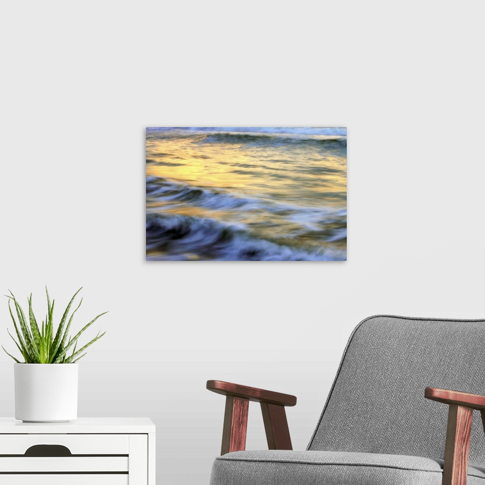 A modern room featuring Soft photograph of a sunset reflecting light on the ocean waves.