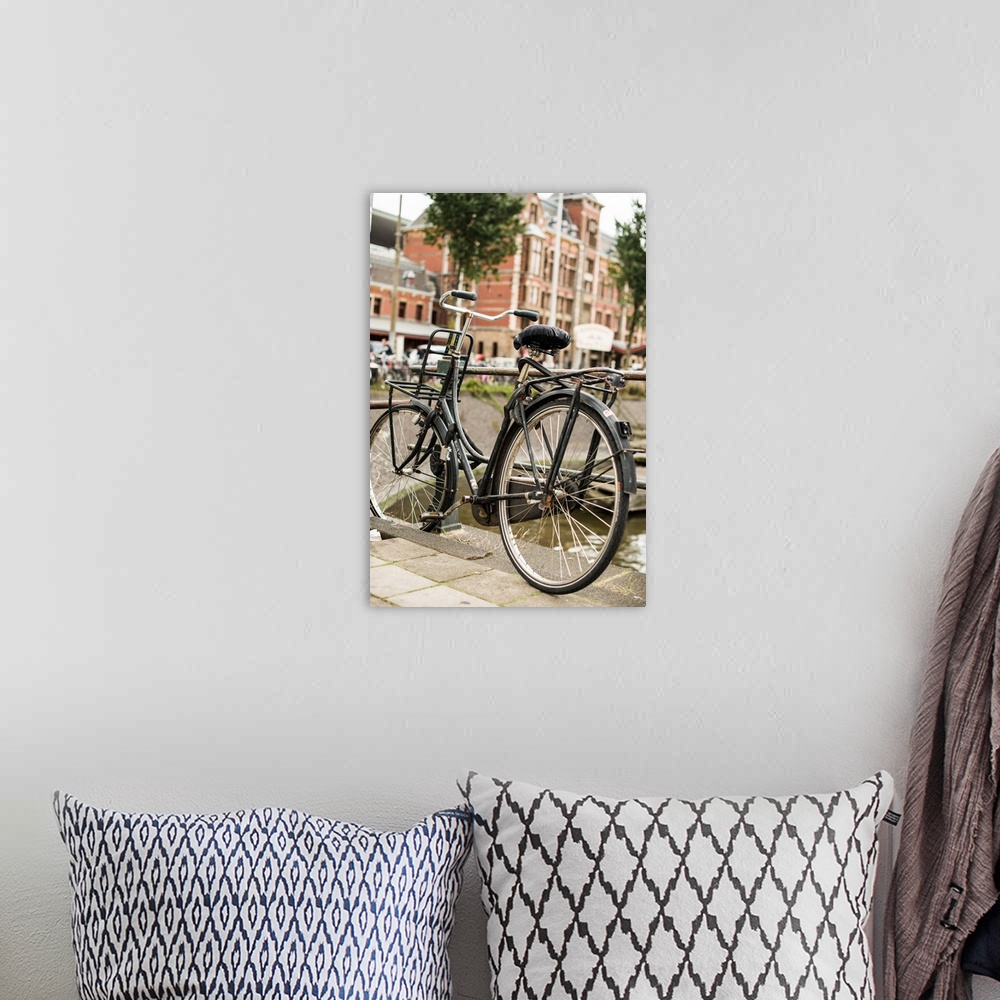 A bohemian room featuring A bicycle leaning against a railing in the Netherlands.