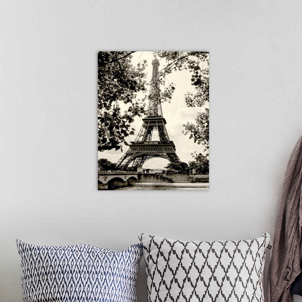 A bohemian room featuring Photograph of famous Paris, France monument with lake below and tree leaves hanging in the foregr...
