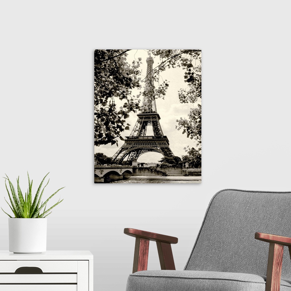 A modern room featuring Photograph of famous Paris, France monument with lake below and tree leaves hanging in the foregr...