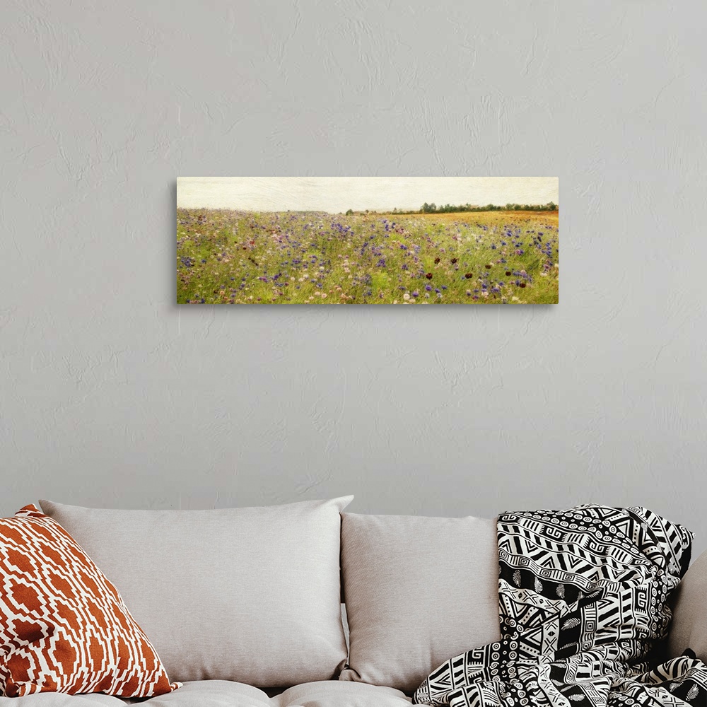 A bohemian room featuring Giant, panoramic painting of a vast field of wildflowers and tall grasses, beneath a clear sky.