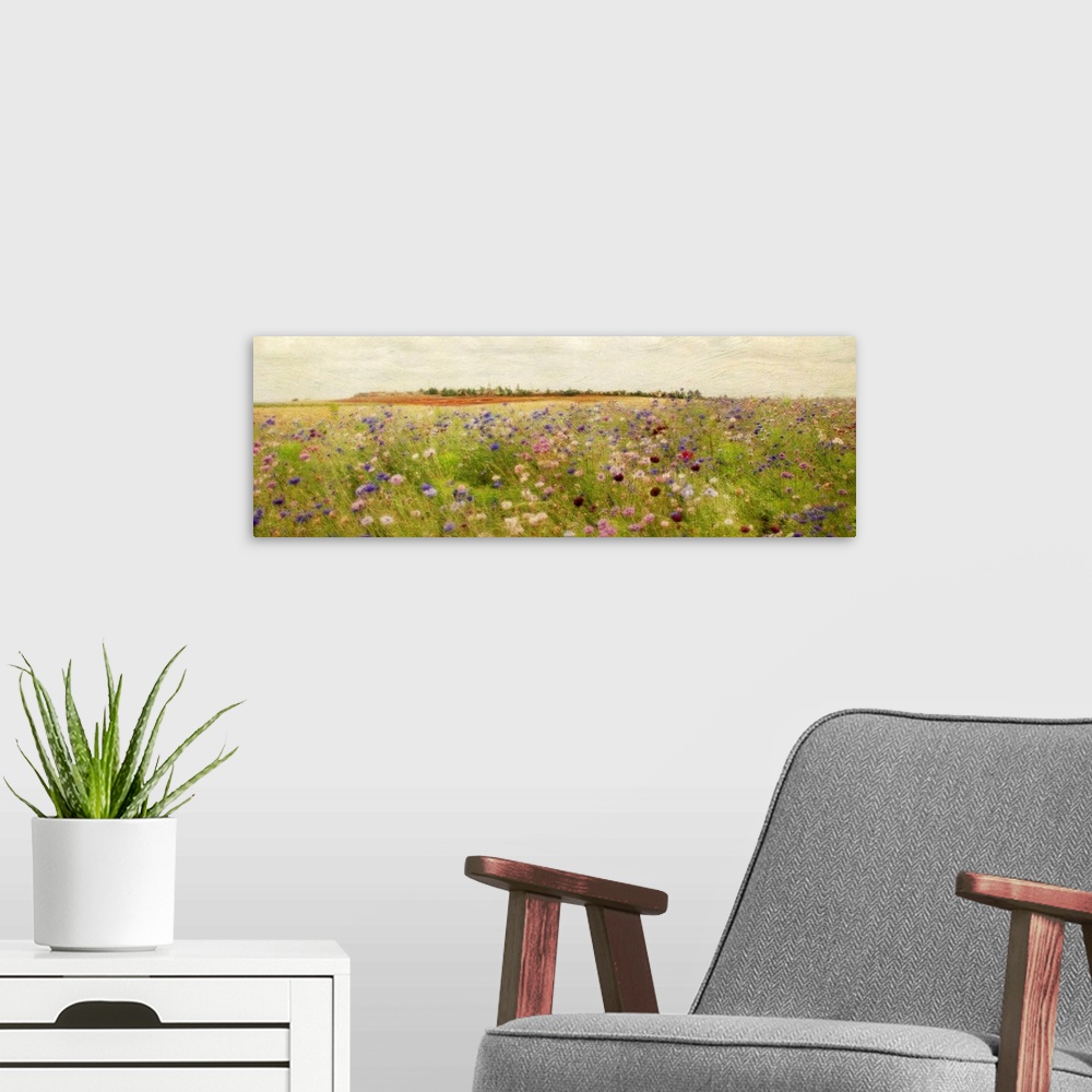 A modern room featuring A colorful field of painted wildflowers beneath a clear, open sky on a large, horizontal wall han...