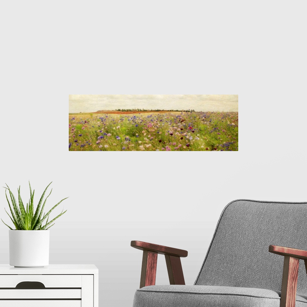A modern room featuring A colorful field of painted wildflowers beneath a clear, open sky on a large, horizontal wall han...