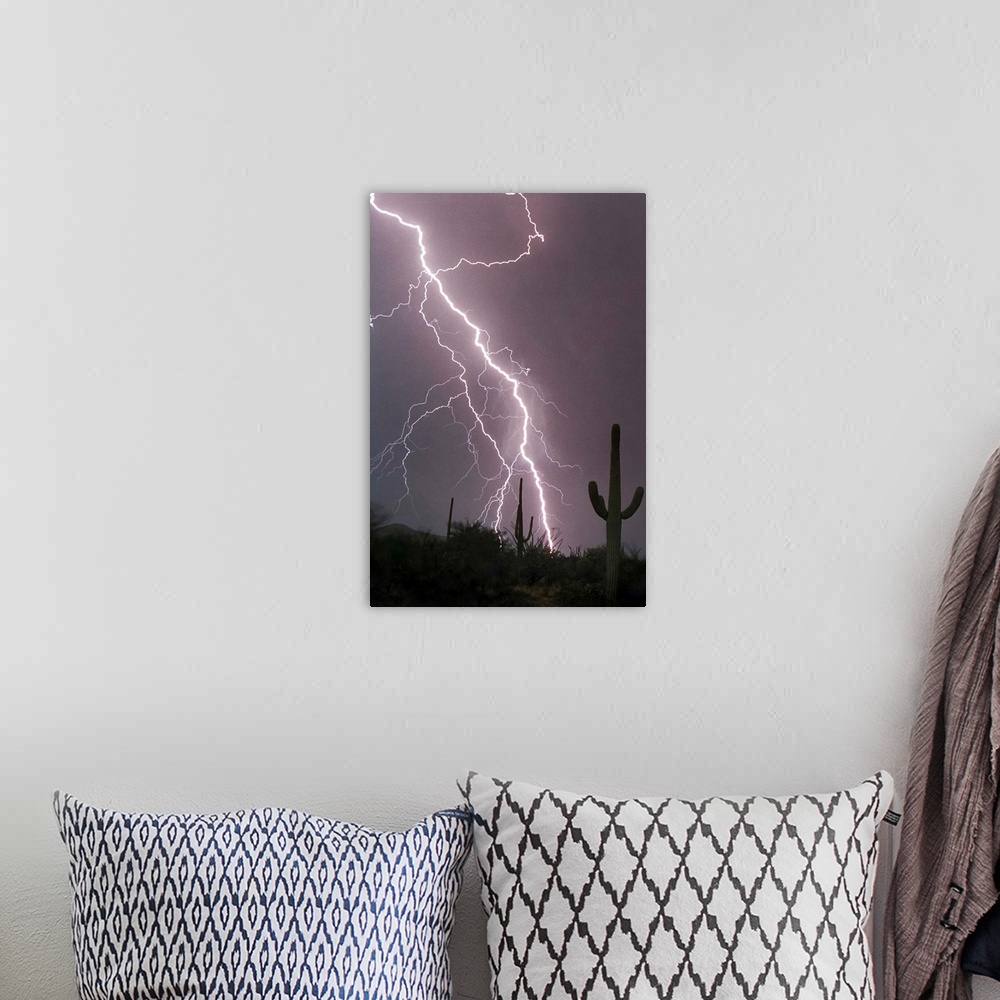 A bohemian room featuring Photograph of lightning striking in a purple sky above a desert with cacti.