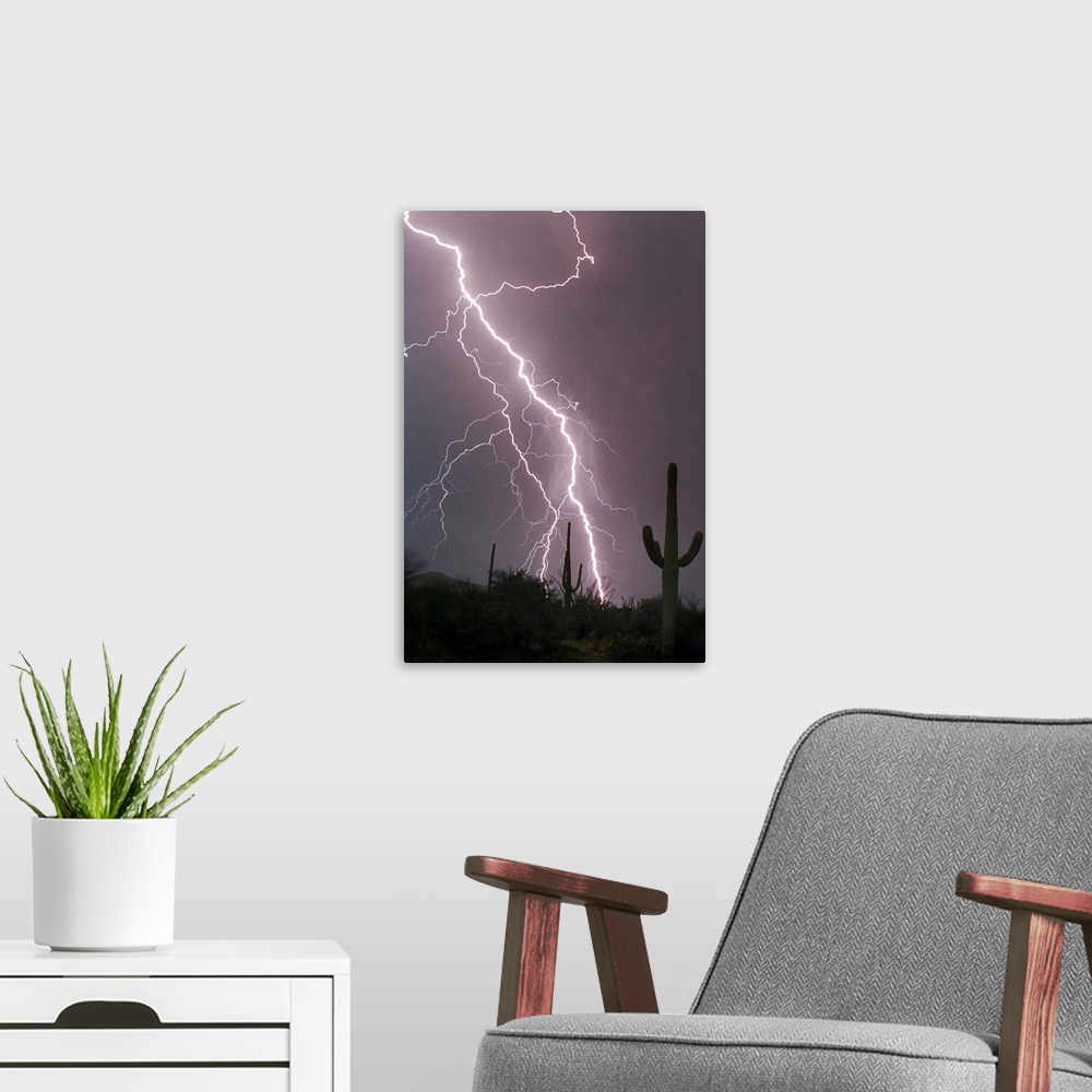 A modern room featuring Photograph of lightning striking in a purple sky above a desert with cacti.