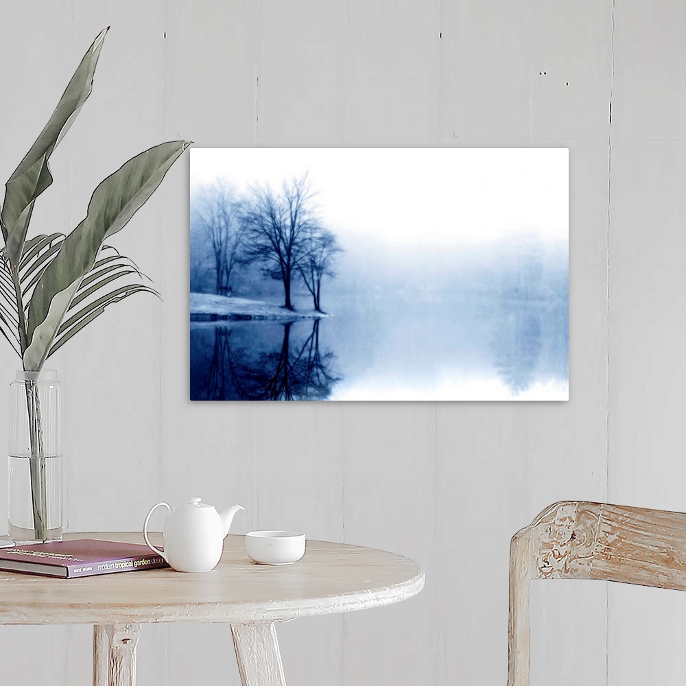 A farmhouse room featuring A photograph taken of a lake with bare trees off to the left side and more trees behind dense fog...
