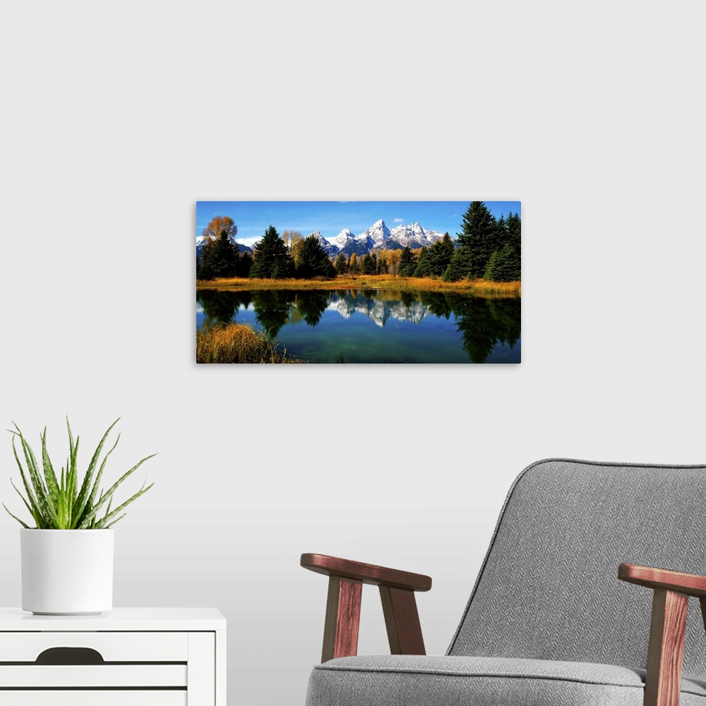 A modern room featuring Panoramic view of the Grand Tetons reflected in a lake in Wyoming.