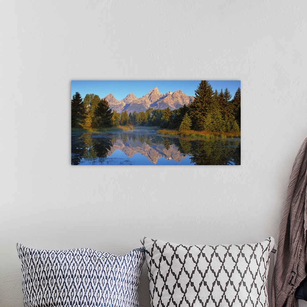 A bohemian room featuring View of the Grand Teton Mountain range in Wyoming, reflected in a lake.