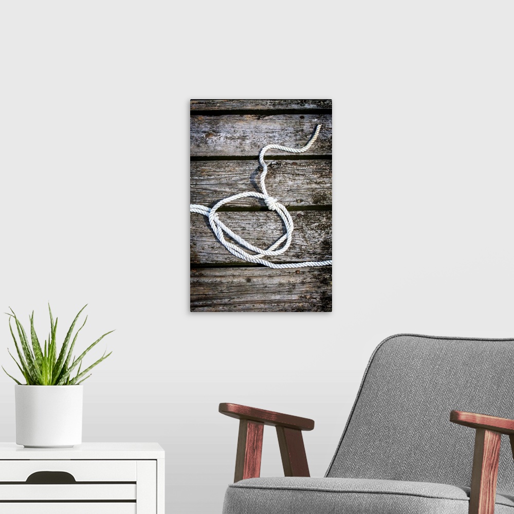 A modern room featuring Photograph of a white rope looped and tied with a knot on a wooden background.