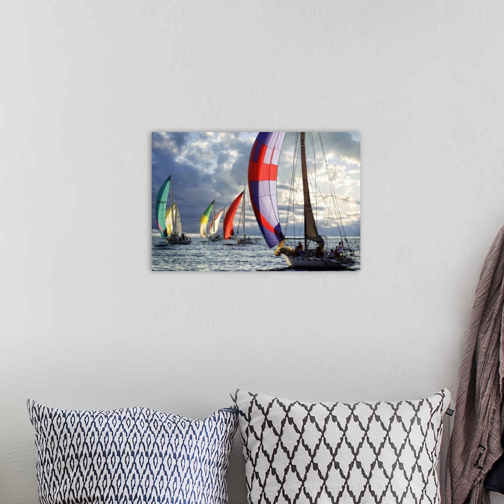 A bohemian room featuring Several sailboats with colorful sails under a cloudy sky in the evening.