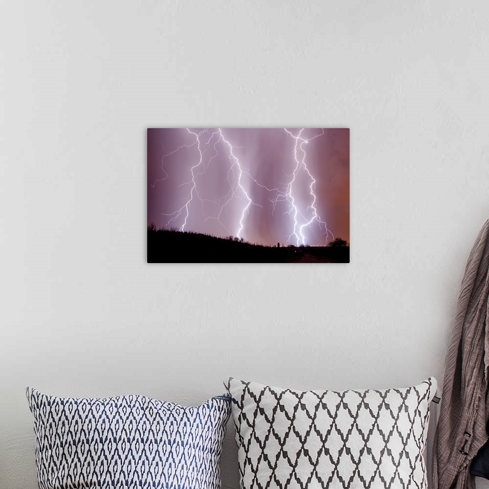 A bohemian room featuring Photograph of three large lightning bolts striking down in an orange, purple, and pink sky above ...