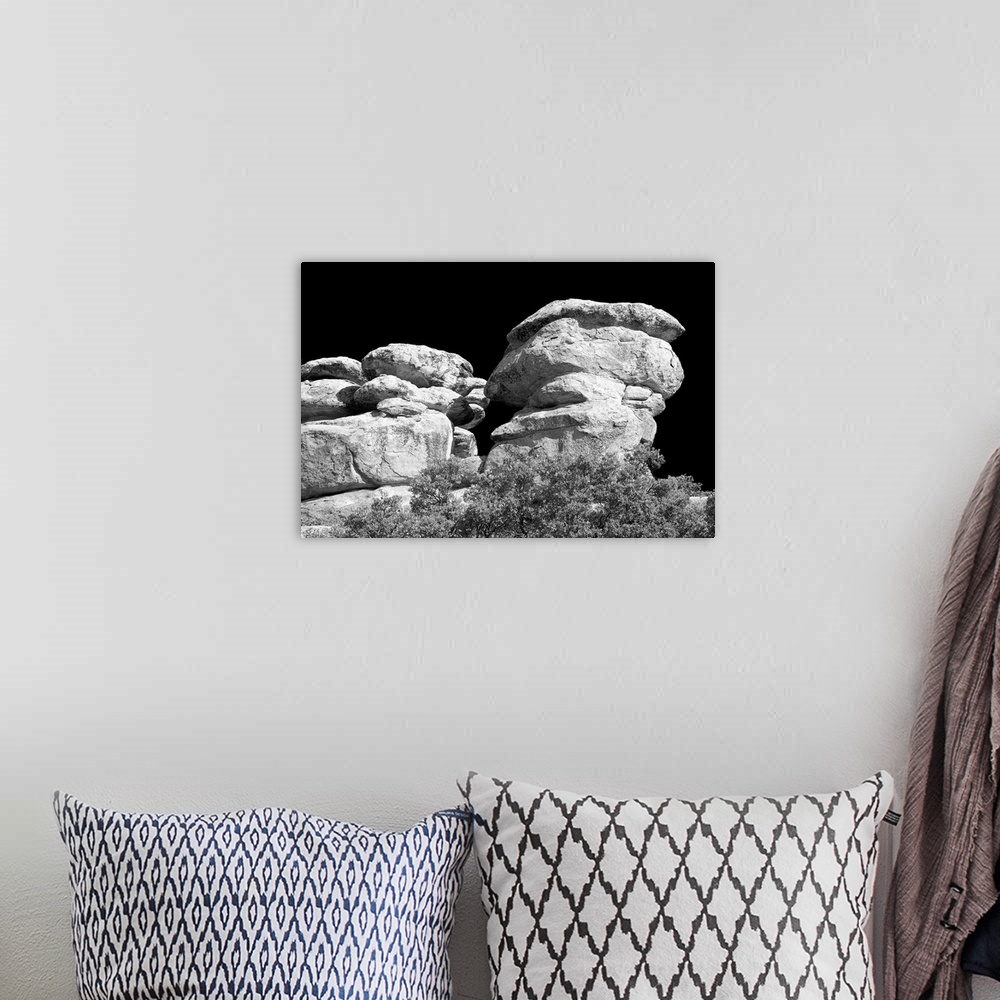 A bohemian room featuring Black and white photograph of stacked rock formations.