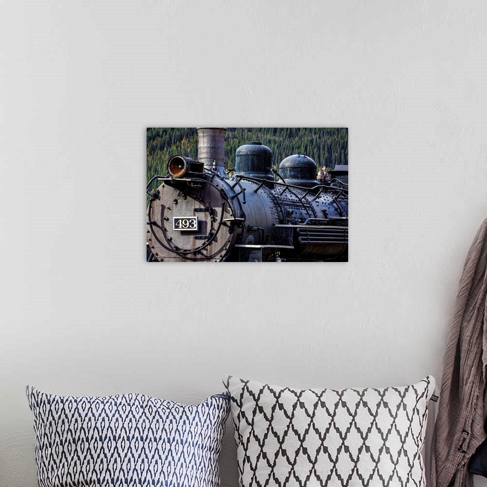A bohemian room featuring Photograph of the front of an old train engine in a rail yard.