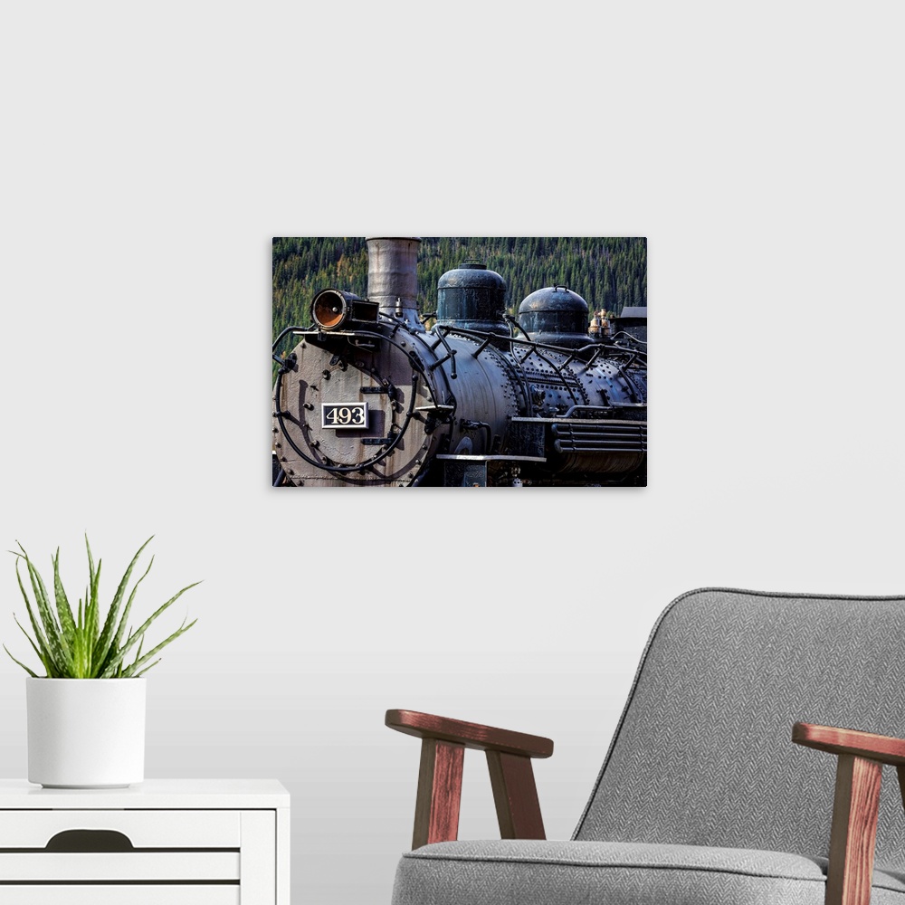 A modern room featuring Photograph of the front of an old train engine in a rail yard.