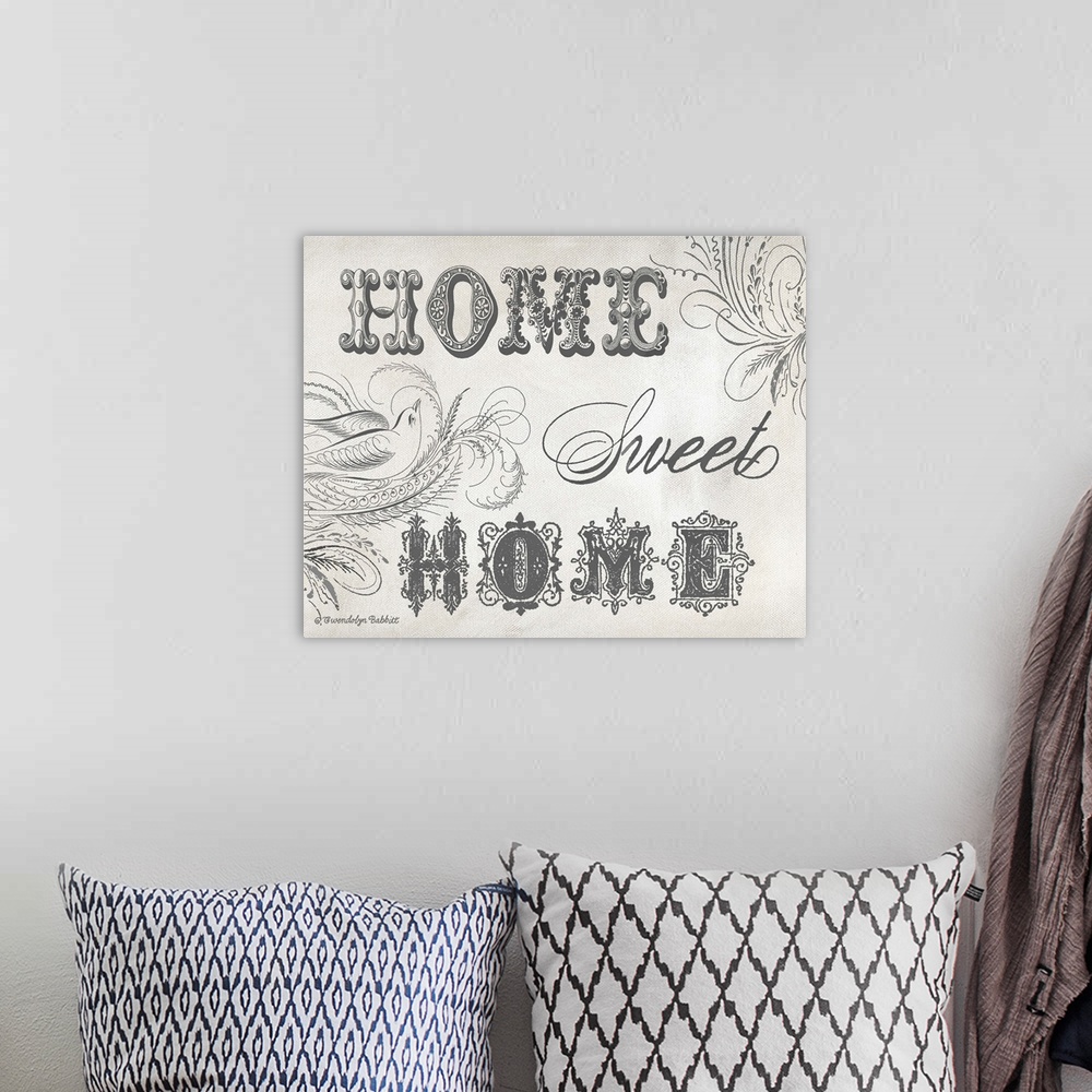 A bohemian room featuring "Home Sweet Home" sign in black and white.