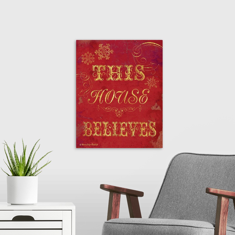 A modern room featuring Holiday decor in red and gold that reads "This House Believes"