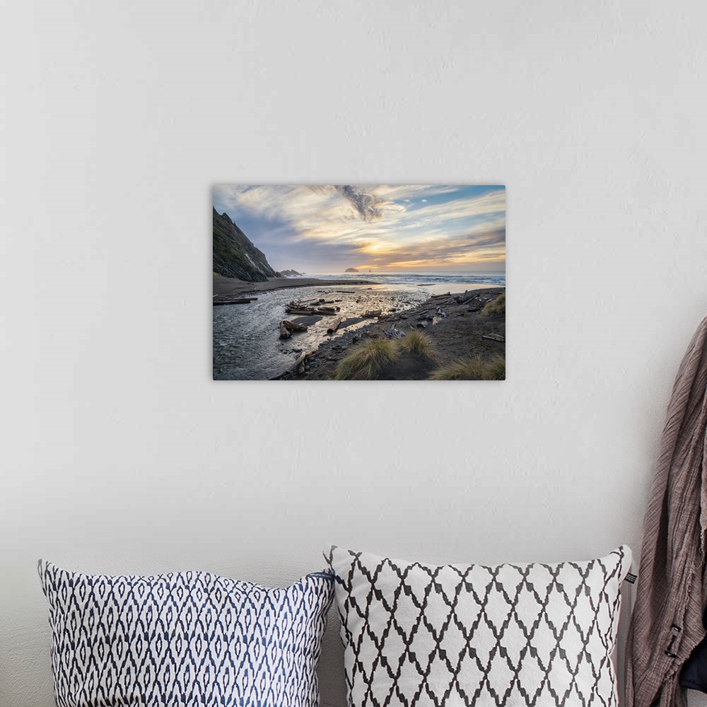 A bohemian room featuring Landscape photograph of a sunrise over the water at Humbug Mountain State Park in Oregon.