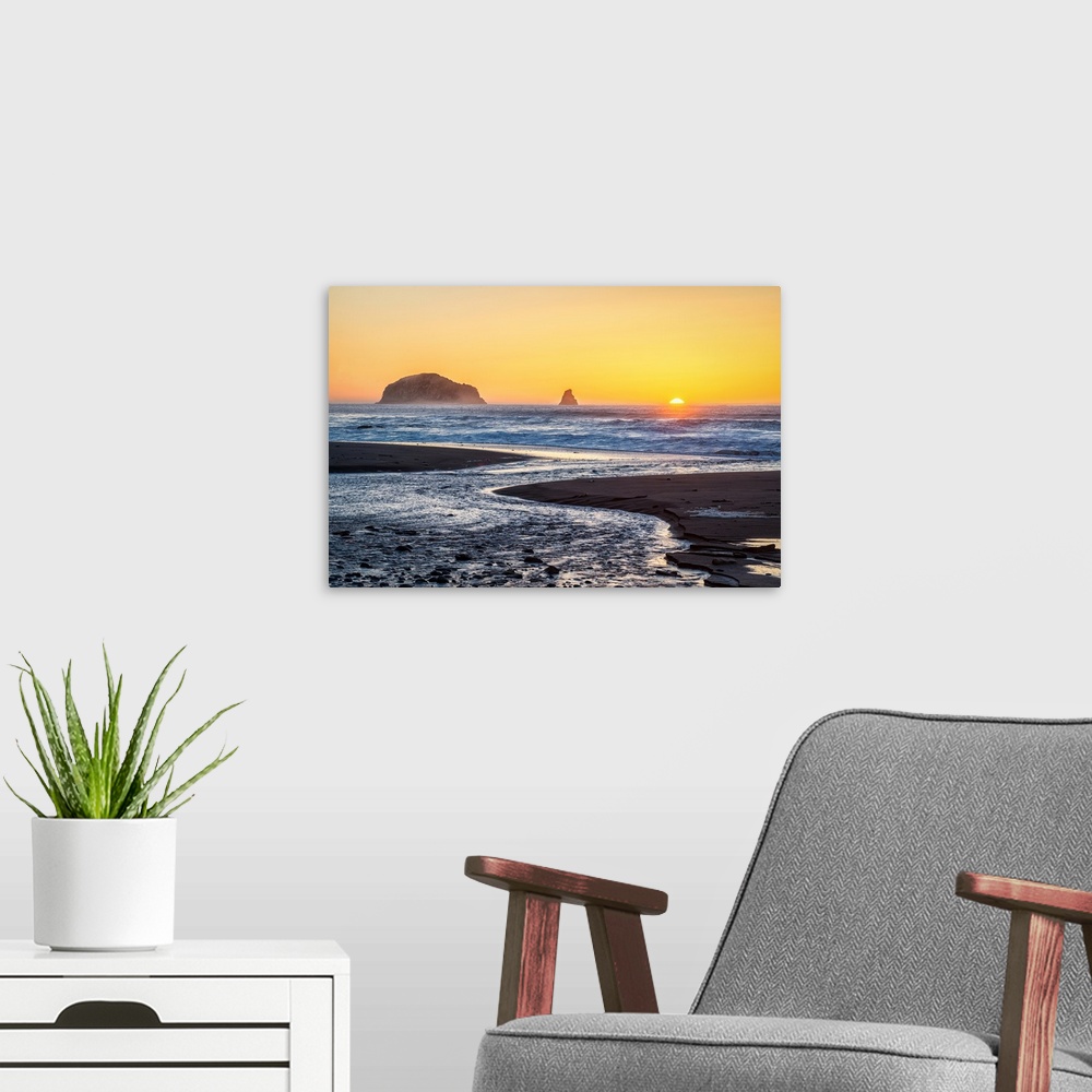 A modern room featuring Landscape photograph of the rocky beach at Humbug Mountain State Park with the sun setting right ...