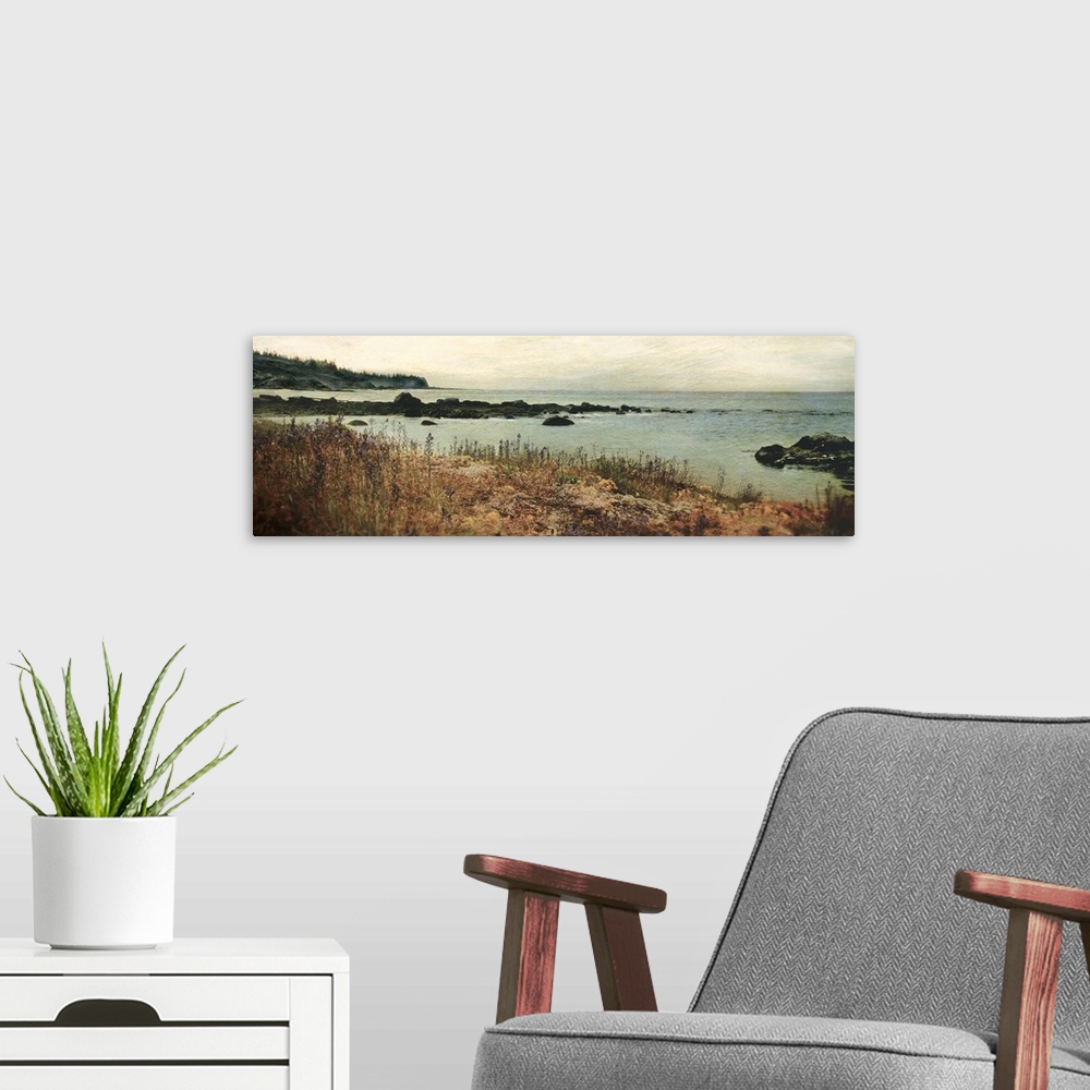 A modern room featuring Panoramic photograph on a giant wall hanging of the grassy shore on an island, overlooking rocks ...