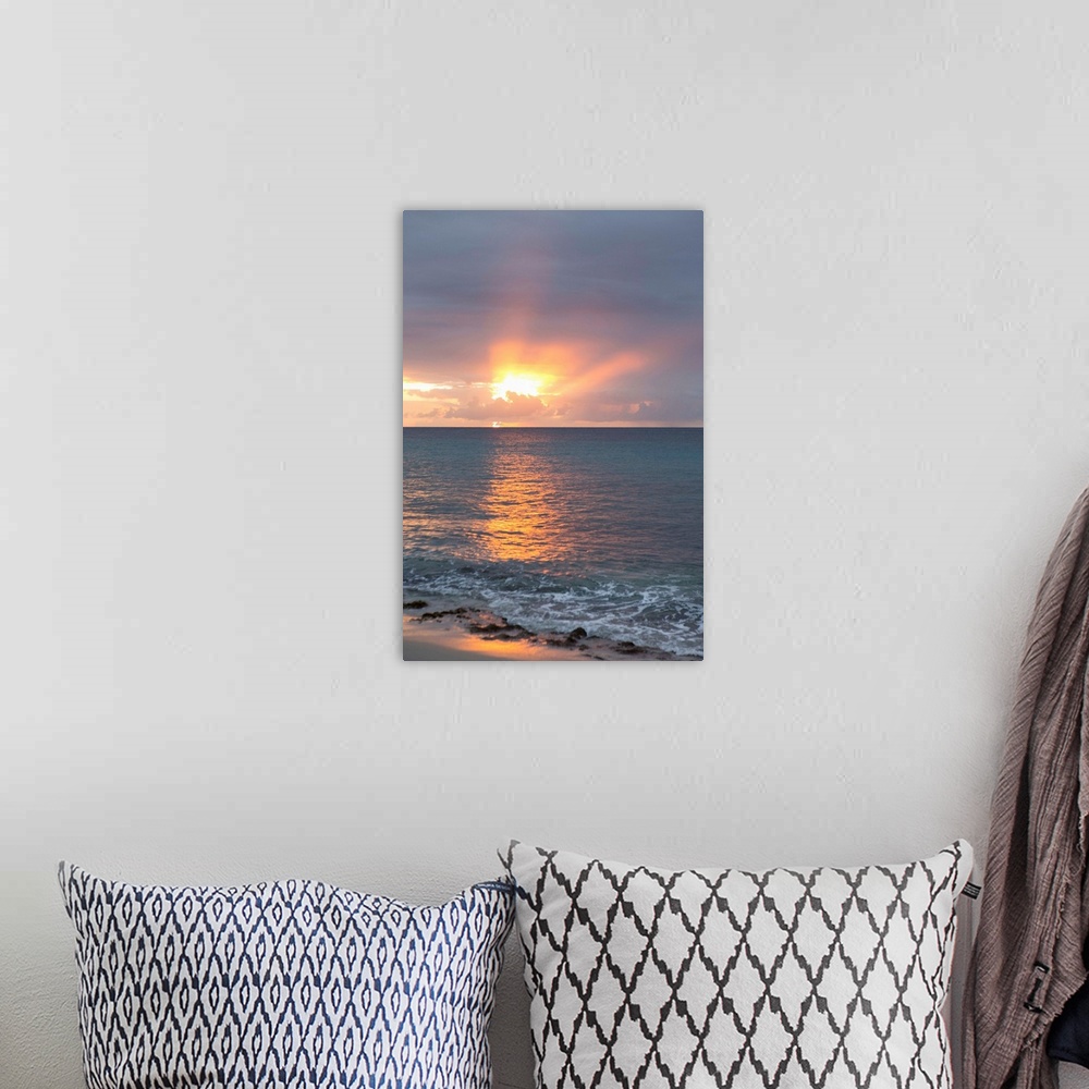 A bohemian room featuring Vertical photograph of a sunset beaming though clouds over a blue ocean.