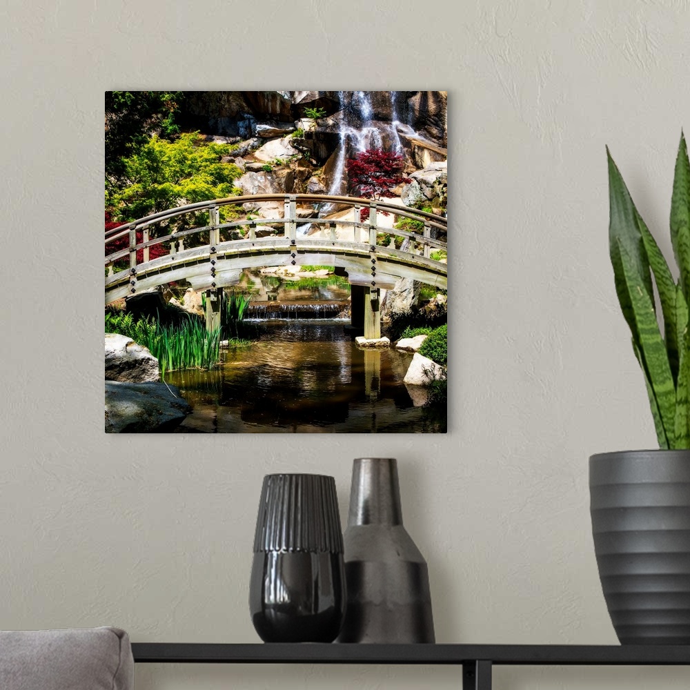 A modern room featuring Square photograph of a bridge over a stream with a waterfall in the background.