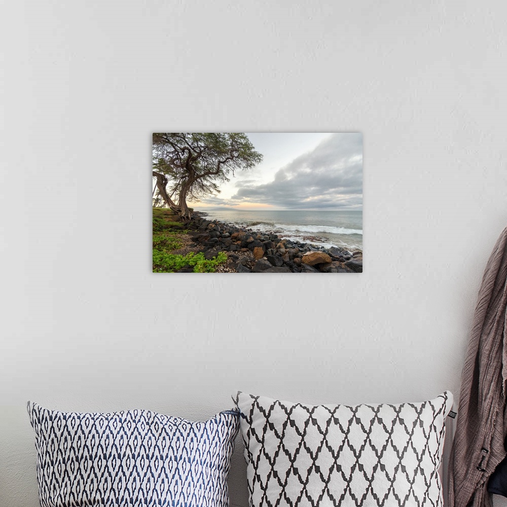 A bohemian room featuring Landscape photograph of a sunrise over the rocky shoreline in Kihei, Hawaii.