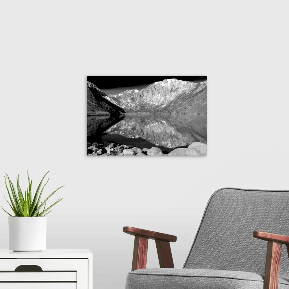 A modern room featuring Black and white landscape photograph of Laurel Mountain peak reflecting into a lake in the foregr...