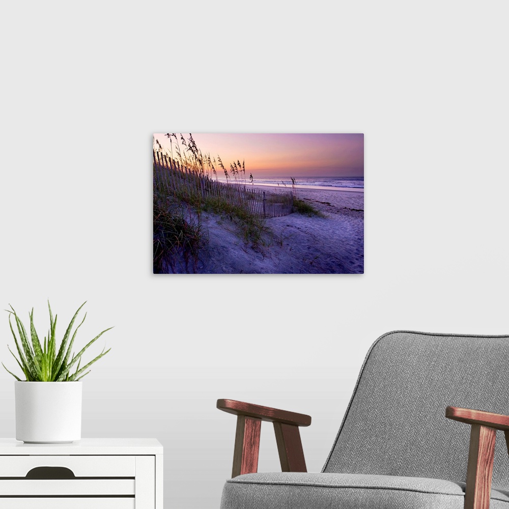 A modern room featuring Big canvas photo art of a beach with dunes and sea oats on the left and the shore meeting the oce...