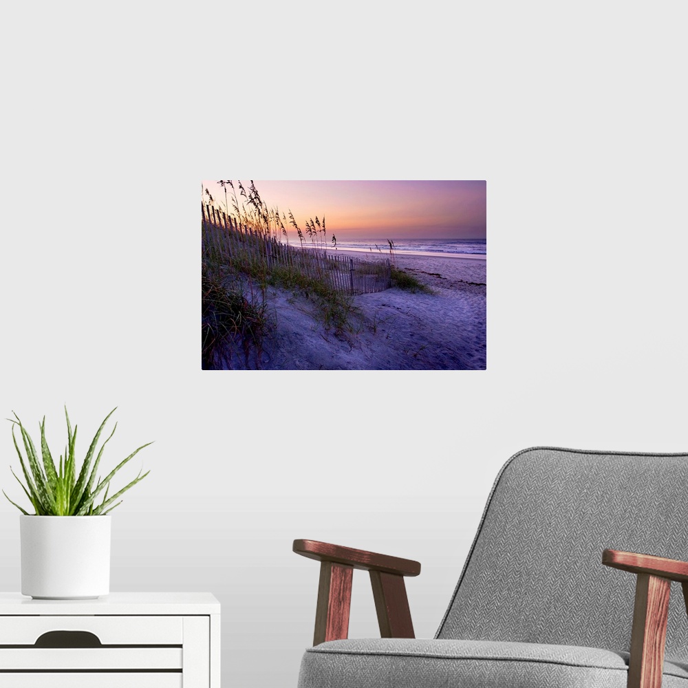 A modern room featuring Big canvas photo art of a beach with dunes and sea oats on the left and the shore meeting the oce...