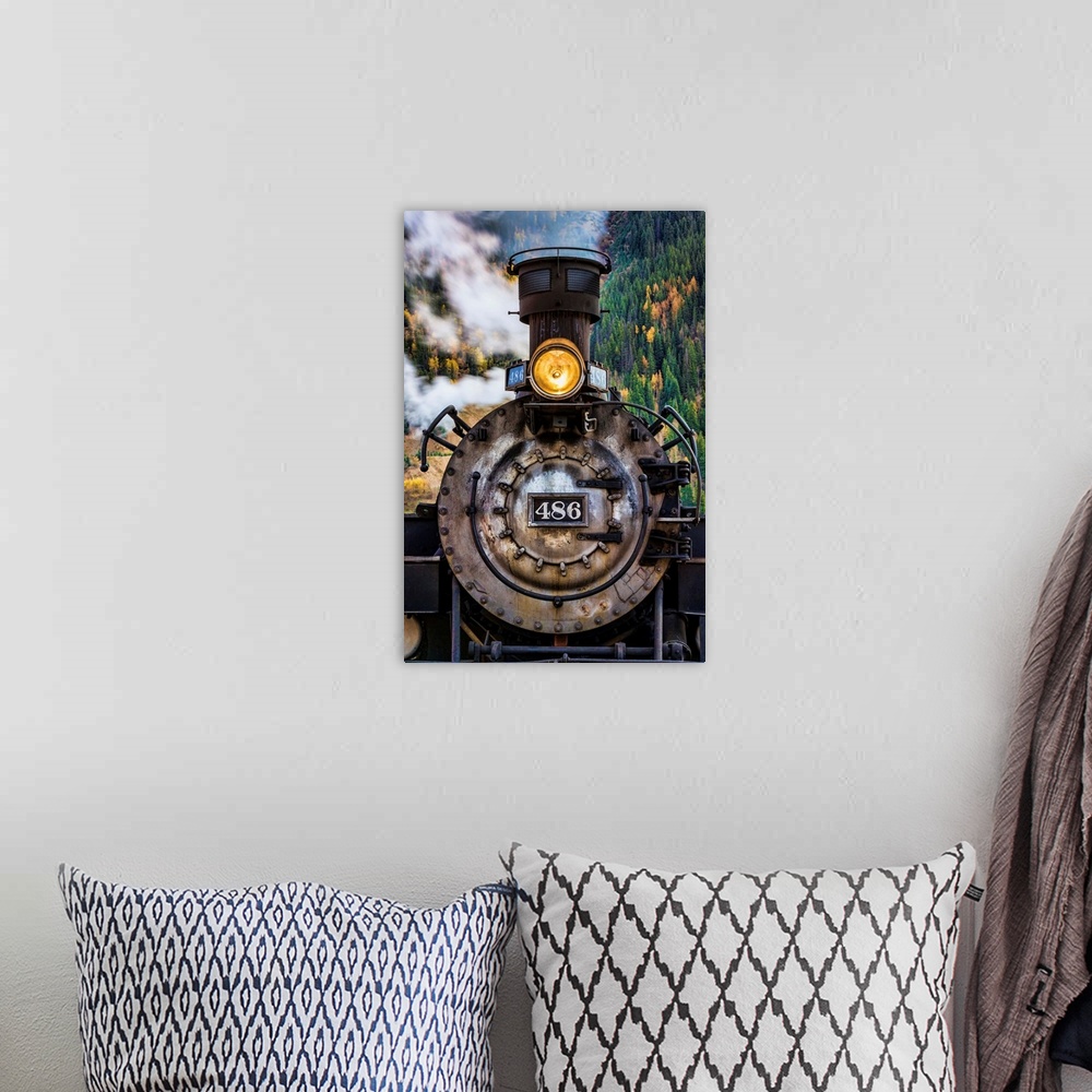 A bohemian room featuring Photograph of the front of an old train engine with steam.