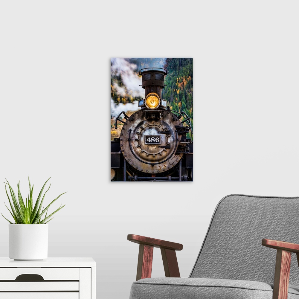 A modern room featuring Photograph of the front of an old train engine with steam.