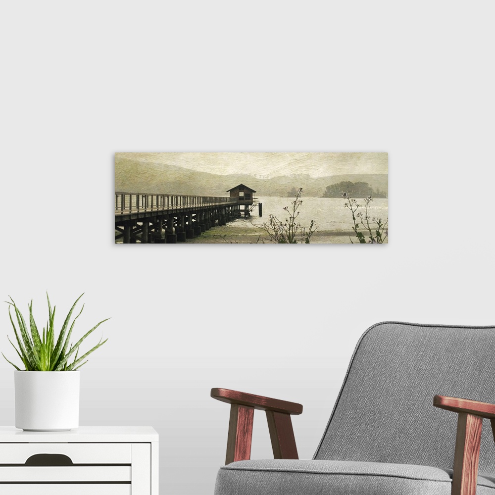 A modern room featuring Wide angle, fine art photograph of a pier extending into the water, a small hut at the end.  An o...